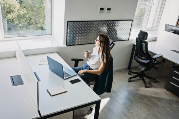 Businesswoman drinking coffee and resting in modern office. Good mental health at work