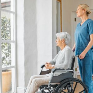 Shot of a nurse caring for a senior woman in a wheelchair in a retirement home