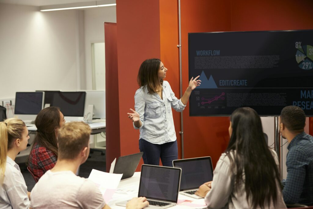 Teacher Talking To Students In College Class