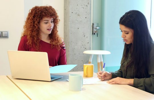 work meeting of two young women signing documents